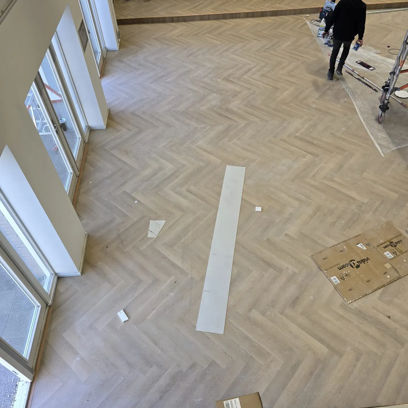 Grote ruimte met een nieuwe visgraatvloer tijdens de renovatie