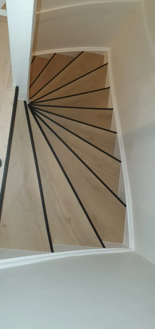 Draaitrap met houtlook treden en zwarte trapprofielen
