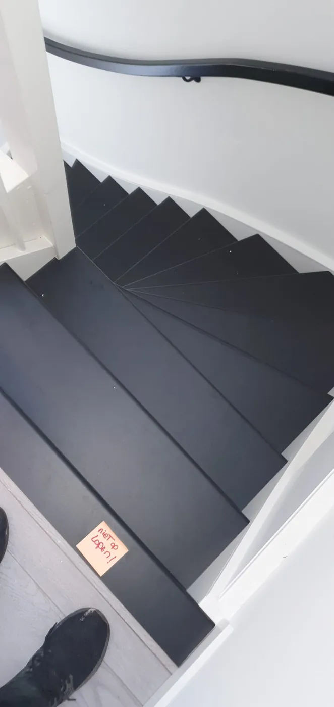Bovenaanzicht van een trap met zwarte treden