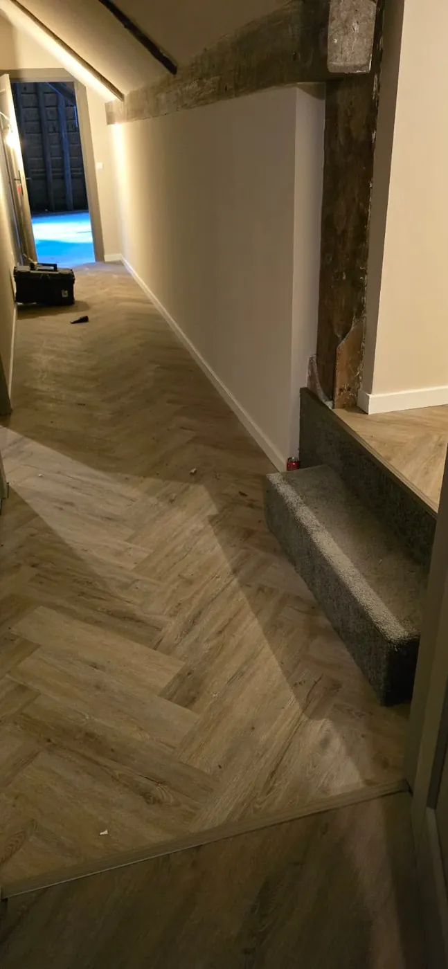 Gang met een visgraatvloer en een houten balk