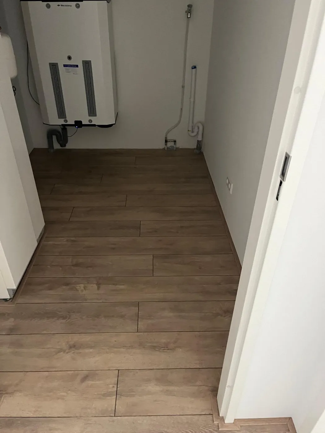Bruine houtlook vloer in een kleine ruimte met een deur